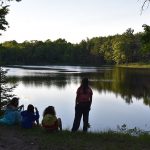 Campers sitting by lake