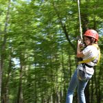 Kid repelling from rock climbing